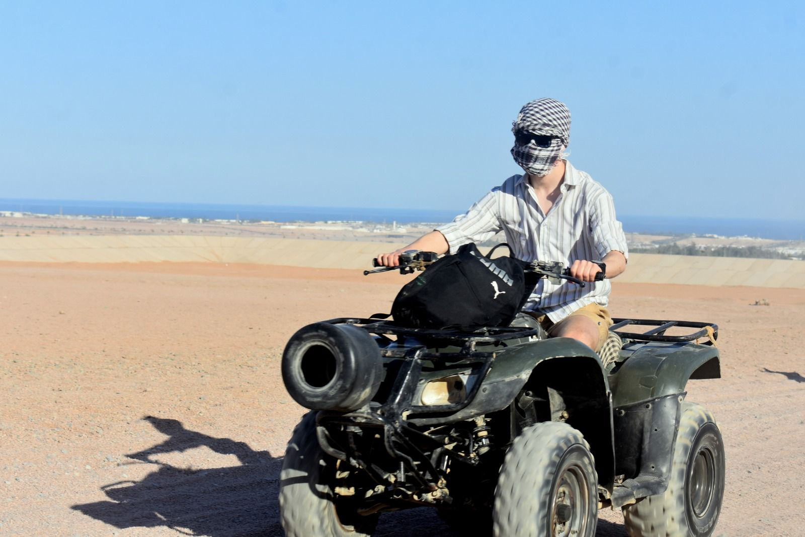 A rider on a quad bike on sandy terrain